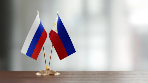 istock Russian And Philippines Flag Pair On A Desk Over Defocused Background 951656506