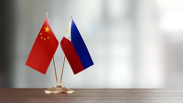 istock Chinese And Philippines Flag Pair On A Desk Over Defocused Background 951656856