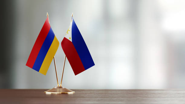 istock Armenian And Philippines Flag Pair On A Desk Over Defocused Background 951657222