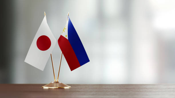 istock Japanese And Philippines Flag Pair On A Desk Over Defocused Background 951657366