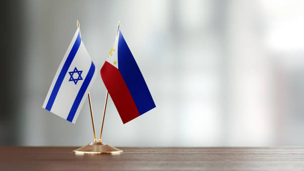 istock Israeli And Philippines Flag Pair On A Desk Over Defocused Background 951657870