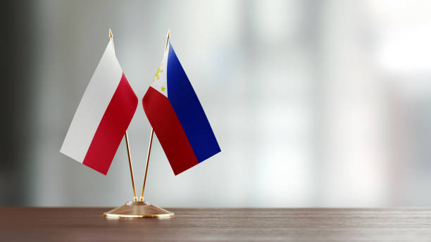 istock Polish And Philippines Flag Pair On A Desk Over Defocused Background 951658204