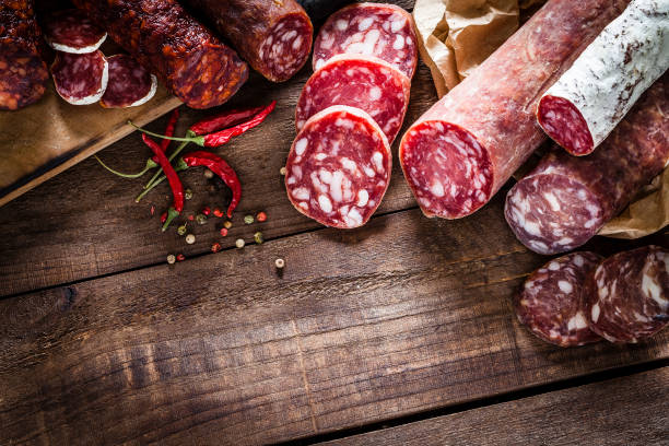 istock Mixed spanish chorizo pieces border on rustic wooden table 951658690