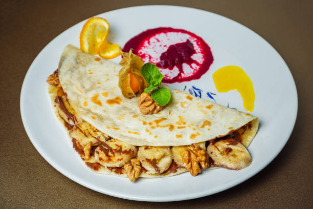 istock Piadina with bananas, nuts and chocolate paste with a flavor of nuts on a white plate 951660312