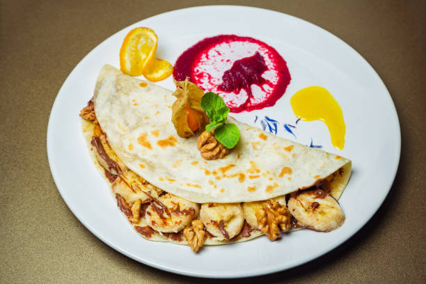istock Piadina with bananas, nuts and chocolate paste with a flavor of nuts on a white plate 951660938