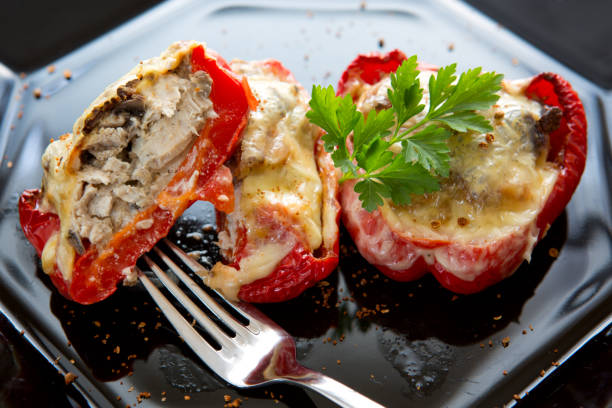 istock Stuffed Red bell peppers with mushrooms on the black plate 951663630
