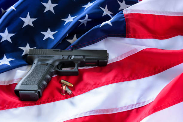 istock A handgun and bullets on American flag background. 951666234