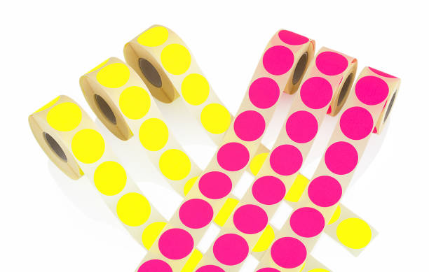 istock Colored label rolls isolated on white background with shadow reflection. Color reels of labels for printers. Labels for direct thermal or thermal transfer printing. Yellow and pink labels top view. 951667844