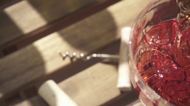 Rose wine is poured smoothly into the glass slow motion