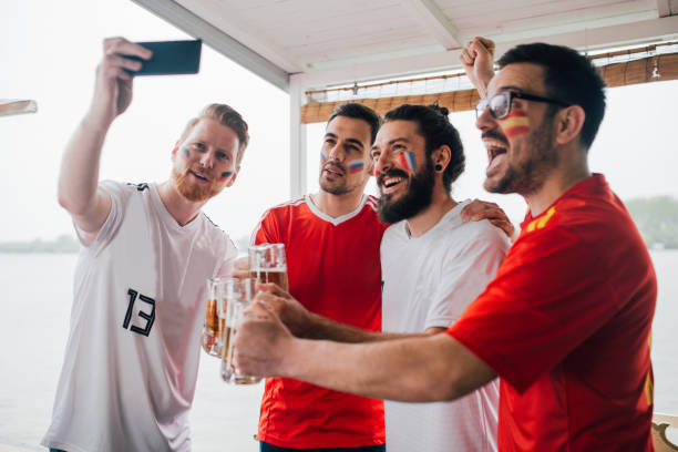 männlichen fußballfans trinken bier und nehmen ein selbstporträt - frankreich wm stock-fotos und bilder