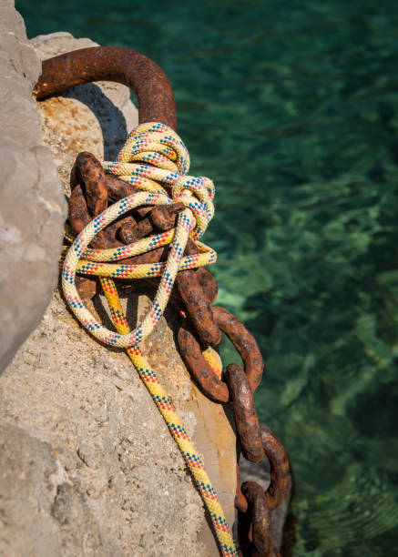 istock Old rusty chain and ropes to moor a boat 951673304