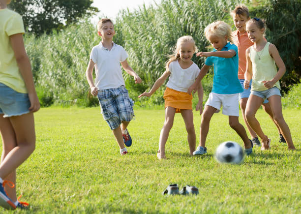 istock children playing football on meadow 951675494