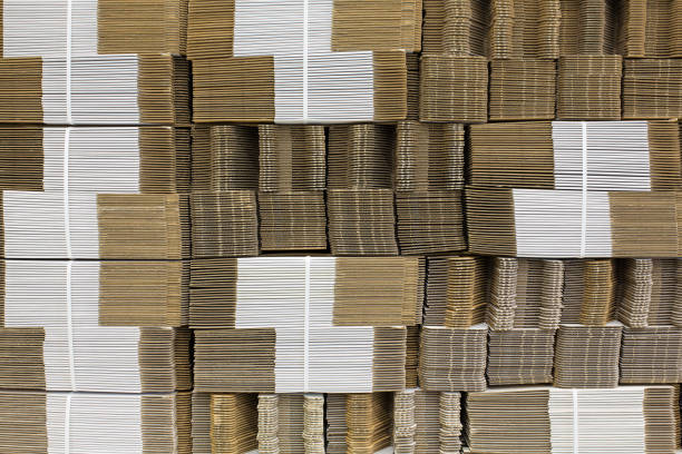 Corrugate cardboard tied with white plastic rope. Corrugated paper single wall. Corrugated fiberboard. Linerboard board. Stack of cardboard boxes. Pleated paper.