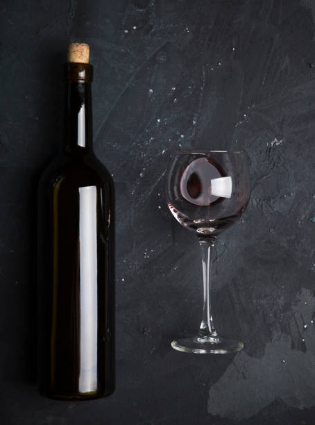 istock Red wine glasses and bottle on stone background. Top view with copy space 951675810