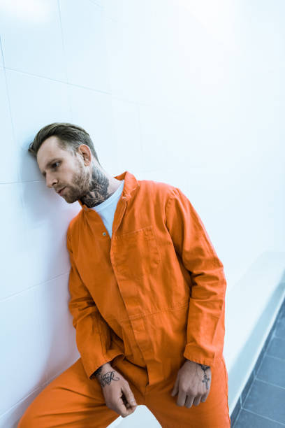 istock tattooed prisoner leaning on wall in prison cell 951676330