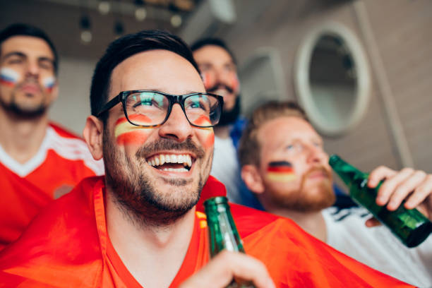 istock Happy soccer fan with face paint holding beer 951677238