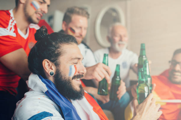 istock Happy people having beer and watching soccer game 951677494