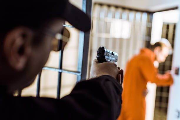 istock prison officer aiming gun at escaping prisoner 951677670