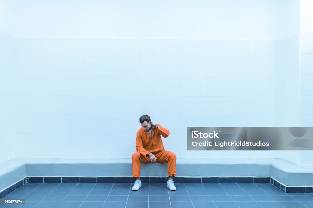 Prisonber Prisoner Sitting On Bench In Prison Cell Stock Photo - Download Image ...