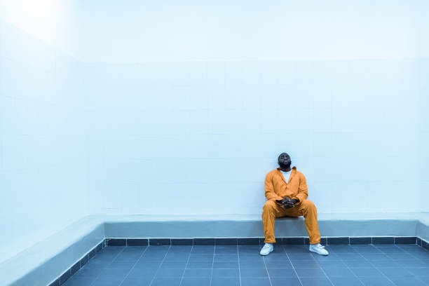 istock african american prisoner sitting on bench in prison cell 951679302