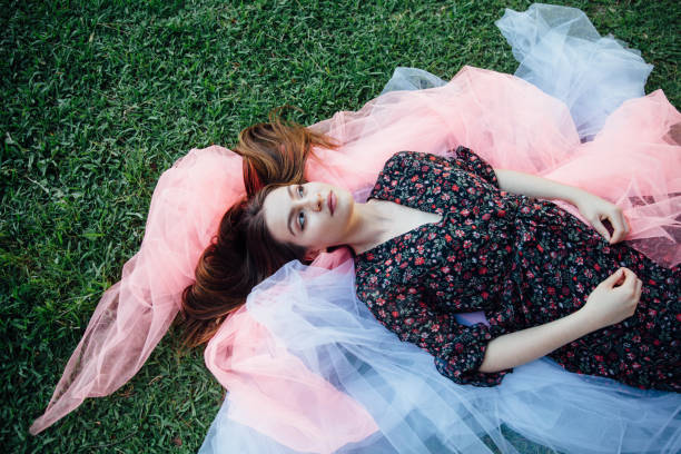 Beautiful young woman lying down on tulle netting