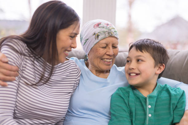 szczęśliwa etniczna kobieta z rakiem obejmuje swoją dorosłą córkę i wnuka - grandmother child grandparent hope zdjęcia i obrazy z banku zdjęć