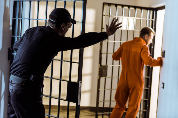 istock security guard showing stop sign to escaping prisoner 951681060
