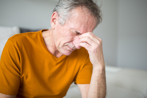 Portrait of senior man suffering from migraine