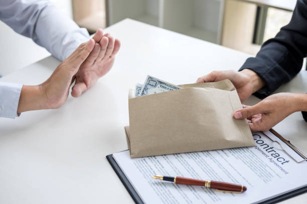 istock Bribery and corruption concept, Businessman refusing receive money in the envelope to agreement contract, A bribe in the form of dollar bills 951683906