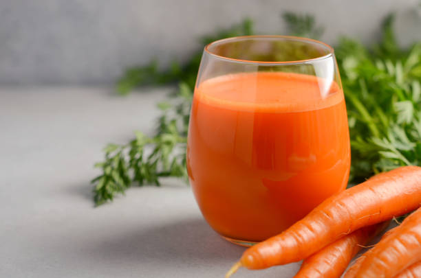 istock Fresh carrot juice on a gray concrete background. 951685026