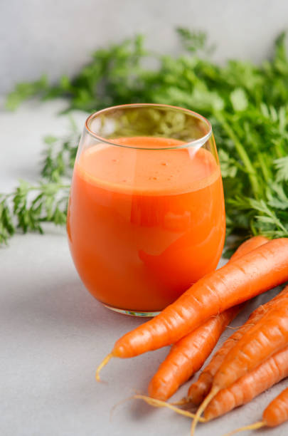 istock Fresh carrot juice on a gray concrete background. 951685034