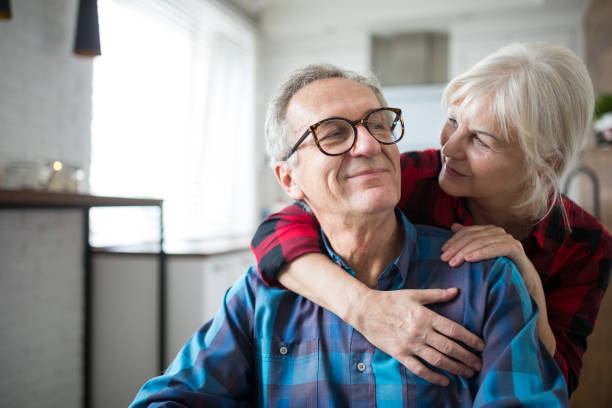 szczęśliwa starsza kobieta obejmująca męża - couple senior adult cheerful old zdjęcia i obrazy z banku zdjęć