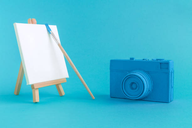 istock Blue camera with blank art canvas and brush background. 951686250