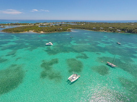 Abacos, Bahamas - Drone shot of anchored cruising boats in clear green water near Elbow Cay