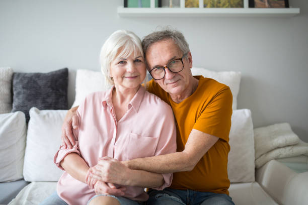 istock Happy senior couple embracing together on couch 951687828