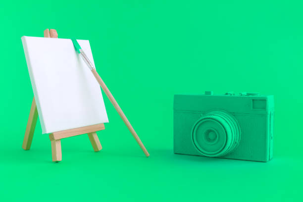 istock Green camera with blank art canvas and brush background. 951689198