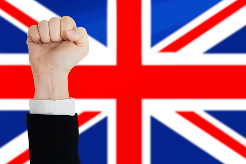 Fist of businessperson in front of british flag.
