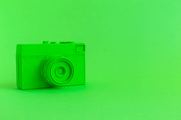 Vintage camera on background in neon green color minimal creative art concept. Space for copy.