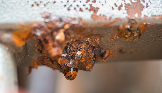 Rusted through heating distributor with water droplets