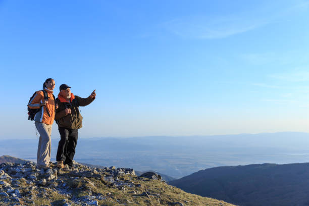 istock Hikers standing on top mountain and looking at view 951693842