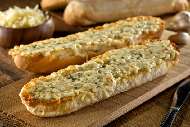 Garlic Bread with Cheese Delicious toasted garlic bread with melted mozzarella cheese and herbs. shredded mozzarella stock pictures, royalty-free photos & images