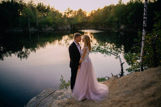 istock newlyweds standing on the lake shore at sunset 951694622