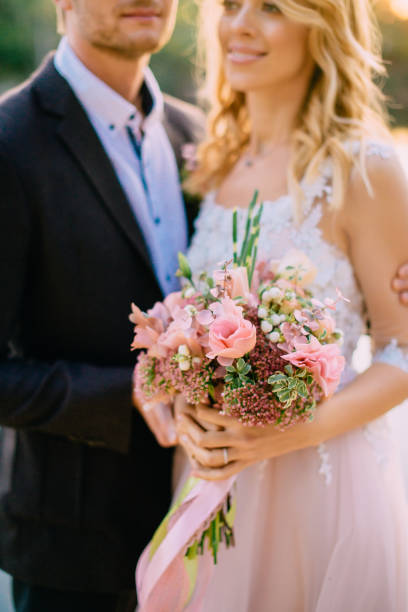 istock hands of the bride with a wedding bouquet, close-up 951694912