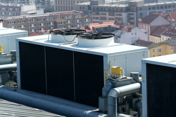 istock Air conditioning ventilators on roof with houses in background 951696400