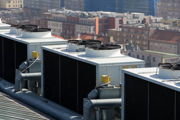 istock Air conditioning ventilators on roof with houses in background 951698062