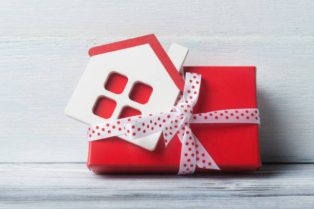 istock House model with gift box over white wooden background. 951700336