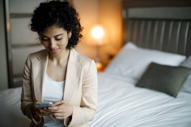 istock Businesswoman using mobile phone in a hotel room 951703686