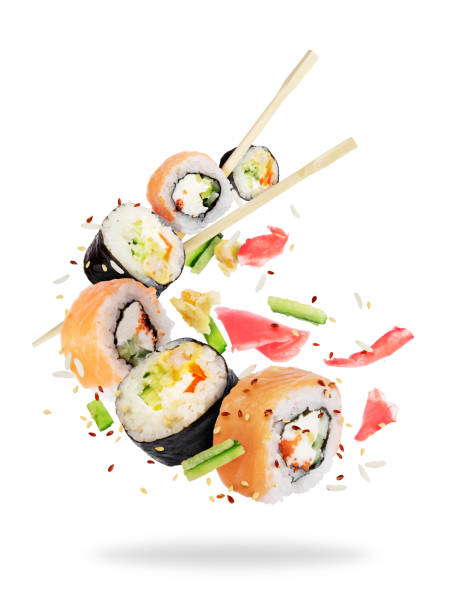 istock Different fresh sushi rolls with chopsticks frozen in the air on white background 951708634