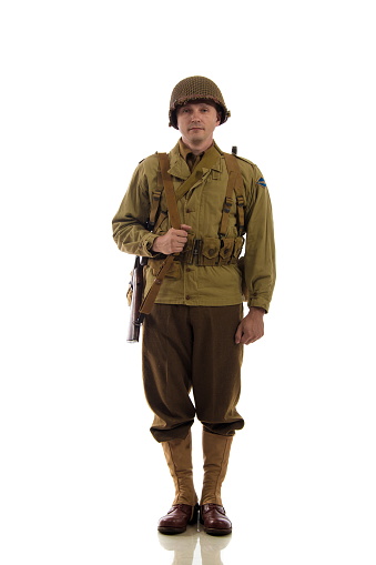 Man actor in military uniform of American ranger of World War II period posing against white background