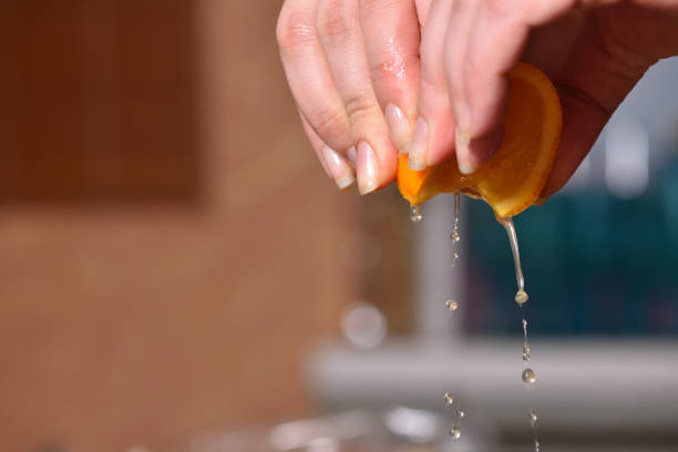 istock Hands squeeze juice from juicy orange 951711778